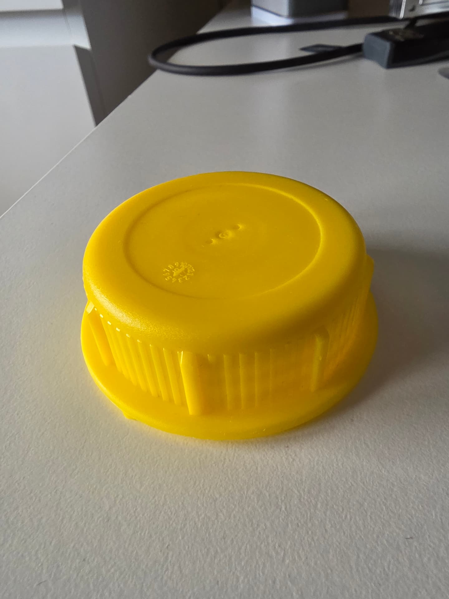3D-printat specialverktyg i gult plast monterat på ett kemikaliedunkslock